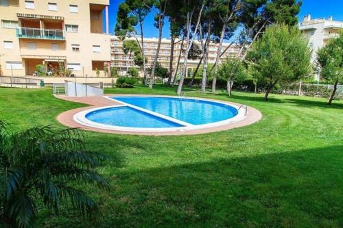 a swimming pool in the middle of a grass field at APARTBEACH GOLDEN I MUY LUMINOSO JUNTO PLAYA y CLIMATIZADO in Salou