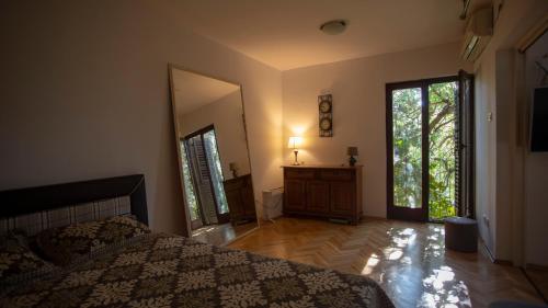 a bedroom with a bed and a dresser and a mirror at Уютная квартира в тени старого дуба in Becici