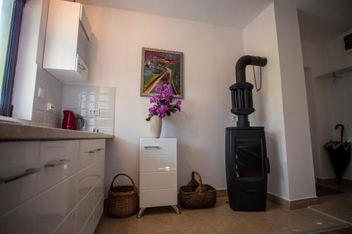 a kitchen with a black stove in the corner at Уютная квартира в тени старого дуба in Becici