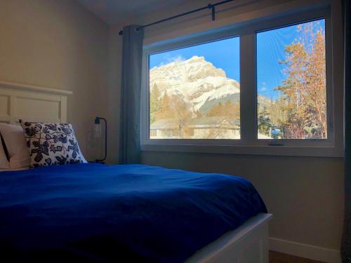 a bedroom with a blue bed and a window at Mountain View Bed & Breakfast in Banff