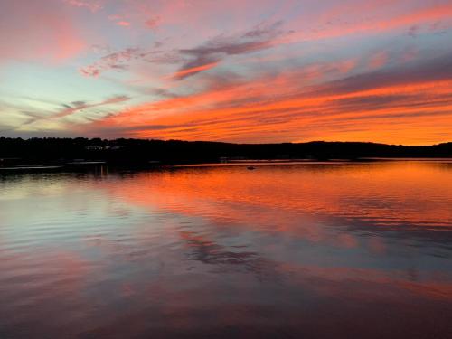 a sunset over a large body of water at Spectacular home with a amazing ocean - river view in Groton