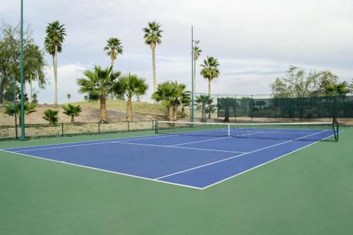 a tennis court with palm trees in the background at Azul Talavera Country Club in Torreón