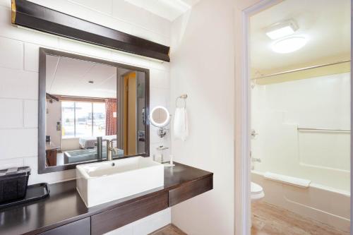 ein Bad mit einem Waschbecken und einem Spiegel in der Unterkunft Starved Rock Motor Inn Travelodge by Wyndham in Streator