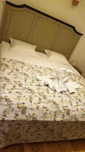 a bed with white sheets and flowers on it at Pensiunea Agroturistica Cerna, Vaideeni - Polovragi in Vaideeni
