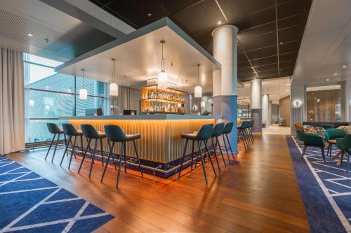 un bar en un restaurante con sillas y una barra en Radisson Blu Hotel Amsterdam Airport, Schiphol, en Schiphol