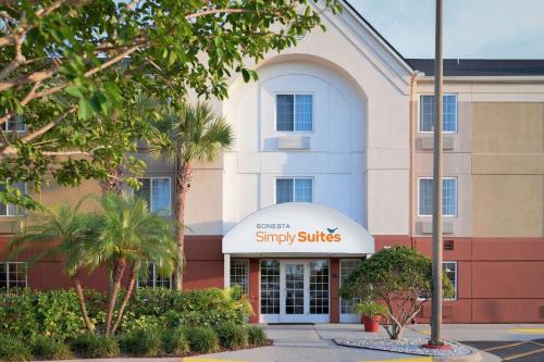 Sonesta Simply Suites Clearwater في كليرووتر: مبنى كبير مع علامة أجنحة سني عليه