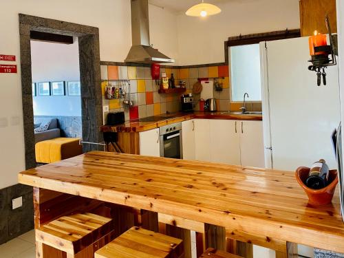 a kitchen with a wooden table and a refrigerator at Sea Roots "Sea Zone" in Mosteiros