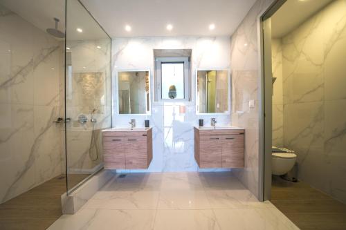 a bathroom with two sinks and a shower at Nafsika Xenia Villa in Plátanos