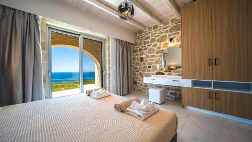 Nafsika Xenia Villa في Plátanos: غرفة نوم مع سرير وإطلالة على المحيط