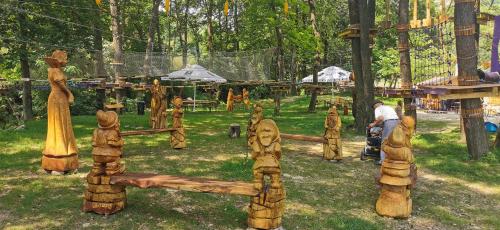 a group of wooden people standing in a park at Pensiunea Agroturistica Cerna, Vaideeni - Polovragi in Vaideeni