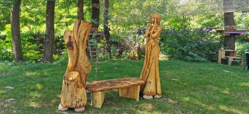 a bench made out of logs in a yard at Pensiunea Agroturistica Cerna, Vaideeni - Polovragi in Vaideeni