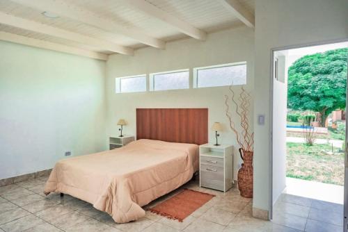 a bedroom with a bed and a large window at Cabañas Villa del Sol in Salta