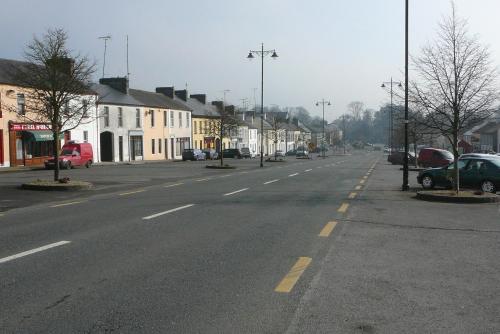 an empty street in a town with cars parked at Inviting 4-Bed House in Strokestown in Grange