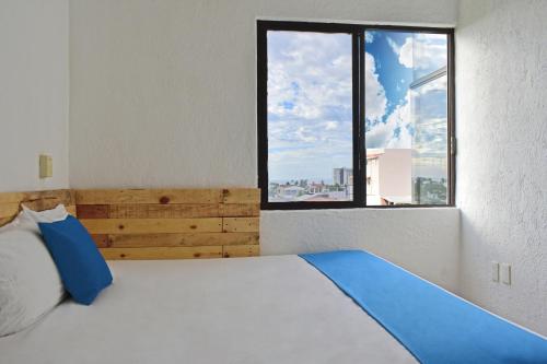 a bedroom with a large bed with a large window at Hotel Blue Home Vallarta in Puerto Vallarta