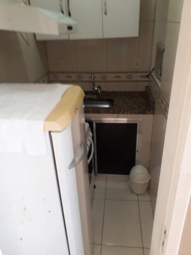 a small kitchen with a sink and a toilet at Menina da Lua in Rio das Ostras