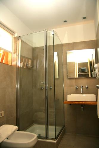 a bathroom with a shower and a toilet and a sink at Galileo Boutique Hotel in San Carlos de Bariloche