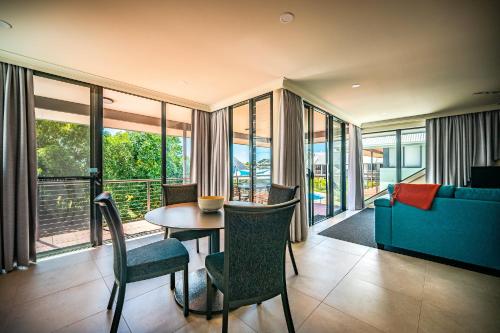 a living room with a table and chairs and a couch at Riverside Holiday Resort Urunga in Urunga