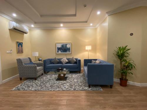 a living room with two blue couches and a rug at ماس للشقق الفندقية الفاخرة in Jeddah