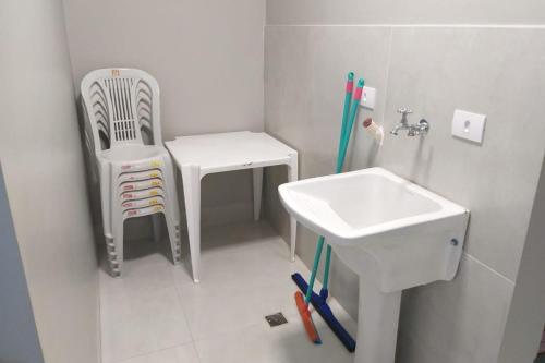 uma pequena casa de banho com um lavatório e uma cadeira em RESIDENCIA CIDADE VERDE 7 em Maringá