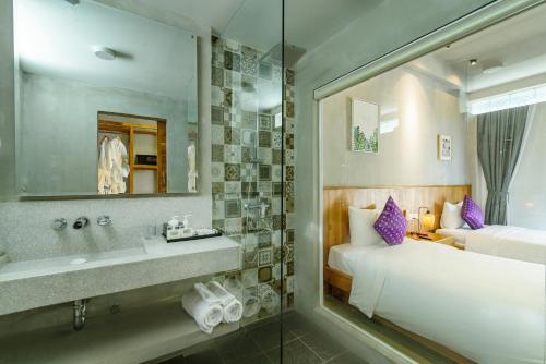 a bathroom with a bed and a sink and a mirror at Phka Kravan Boutique in Kampot