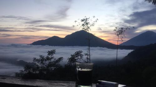 a view of a mountain with a layer of clouds at Tukadsari camping in Kintamani
