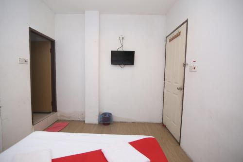 una stanza vuota con un letto e una televisione sul muro di L&C Premium Stay a Kuching