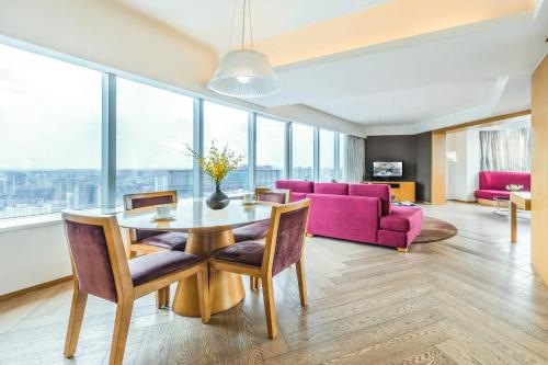 - un salon avec une table et un canapé violet dans l'établissement Somerset Riverview Chengdu, à Chengdu
