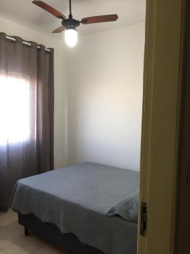 Un dormitorio con una cama con ventilador de techo. en Hospedagem da Rose - Cabo Frio, en Cabo Frío