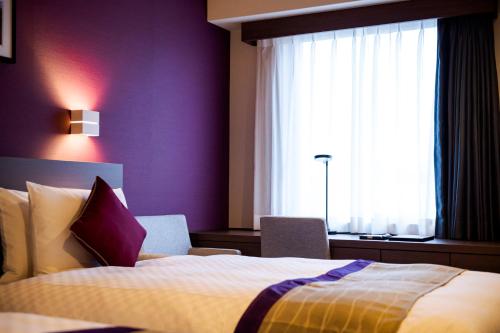 a hotel room with a bed and a window at Best Western Plus Fukuoka Tenjin-minami in Fukuoka