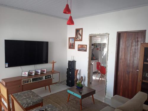 uma sala de estar com uma televisão de ecrã plano na parede em Residencial santana em Feira de Santana