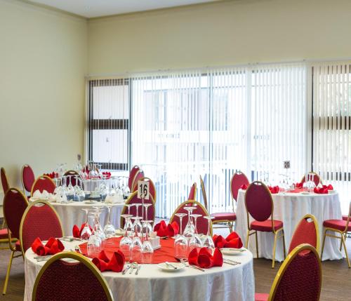 a room with tables and chairs with red roses on them at Boma Inn Eldoret in Eldoret
