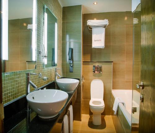 a bathroom with two sinks and a toilet and a tub at Boma Inn Eldoret in Eldoret