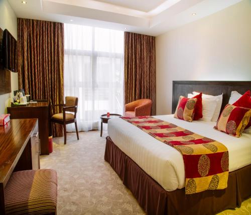 una camera d'albergo con letto e scrivania di Boma Inn Eldoret a Eldoret
