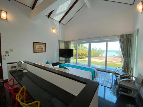 a bedroom with a large bed and a large window at Krabi Beach House, SHA Extra Plus in Ao Nam Mao