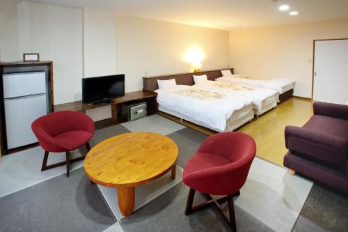a hotel room with a bed and a table and chairs at Yumeoi-so in Aso