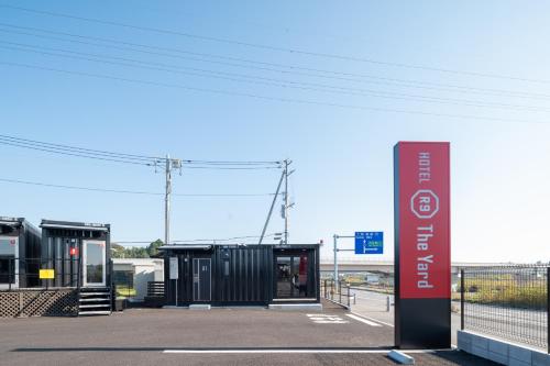 a bus stop with a sign in front of it at HOTEL R9 The Yard Ami in Ami