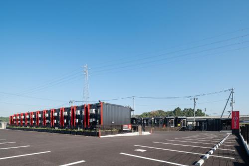 阿見町にあるHOTEL R9 The Yard 阿見の赤いコンテナが並んだ駐車場