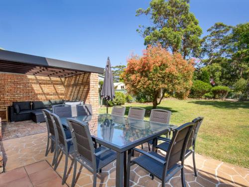 a patio with a glass table and chairs at Anacapri - Pet Friendly - Opposite Beach - Fireplace in Callala Beach