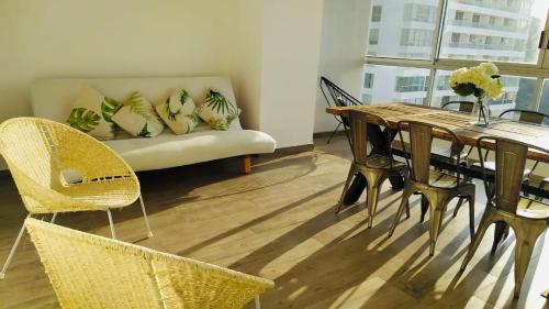 a living room with a couch and a table and chairs at Departamento con Preciosa Vista al Mar en Acapulco Diamante in Acapulco