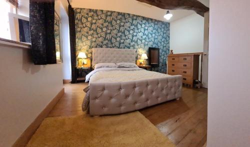 um quarto com uma cama grande e uma parede azul em The Mews @ The Pheasant em Ironbridge