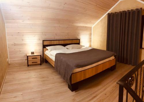 a bedroom with a bed and a wooden wall at Gostynna sadyba Kit Bayun in Teterivka