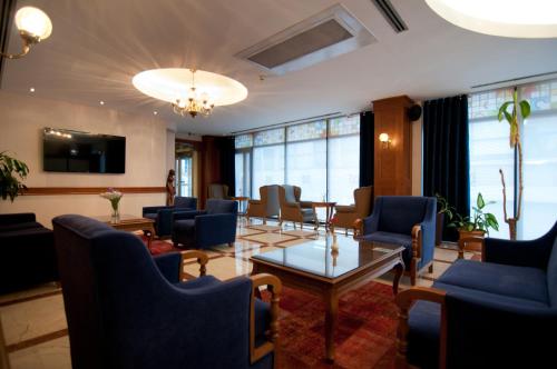 a living room filled with furniture and a large window at Taksim Metropark Hotel in Istanbul