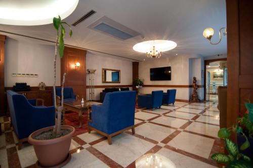 a waiting room with blue chairs and a table at Taksim Metropark Hotel in Istanbul