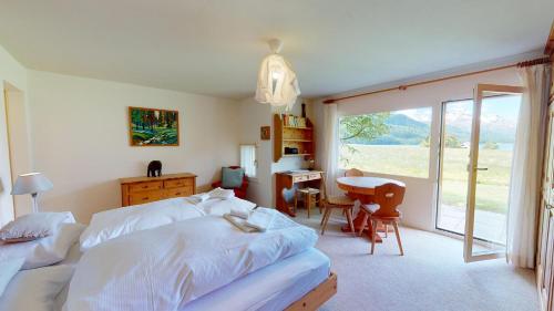 a bedroom with two beds and a desk and a table at Abitaziun Sur Sass - Silvaplana Surlej in Surlej