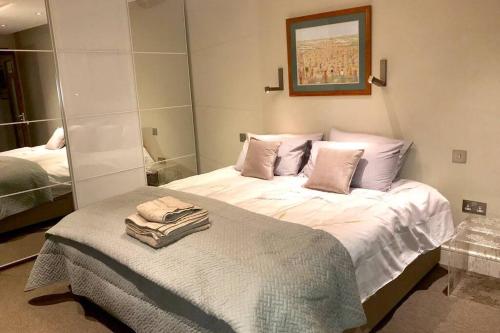 a bedroom with a bed with towels on it at Stylish large cool 3 bed 3 bath Marylebone +AC in London