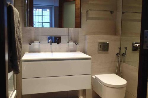 a bathroom with a white sink and a toilet at Stylish large cool 3 bed 3 bath Marylebone +AC in London