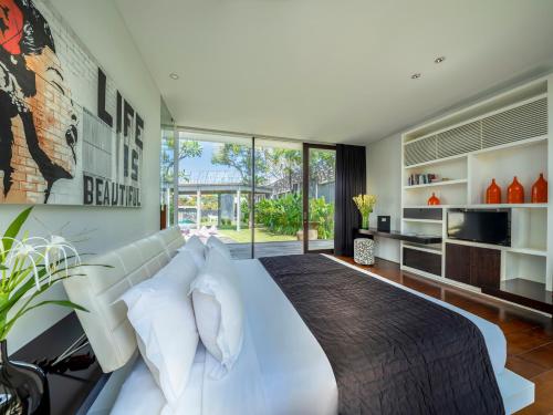a bedroom with a large white bed with white pillows at Villa Issi by Elite Havens in Seminyak