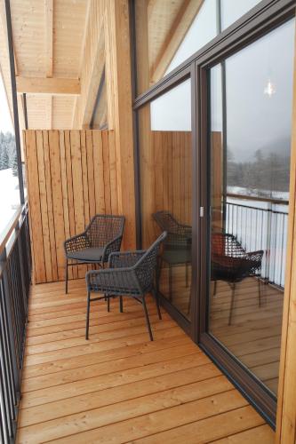a screened porch with rocking chairs and windows at Unterbergerhof in Val di Vizze