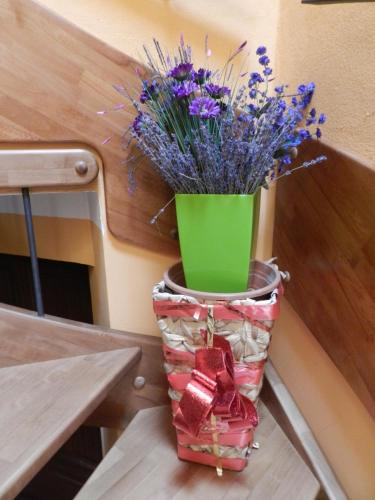a vase filled with purple flowers sitting on a table at B&B l'Angolo di Rosina con ristorante in Novello
