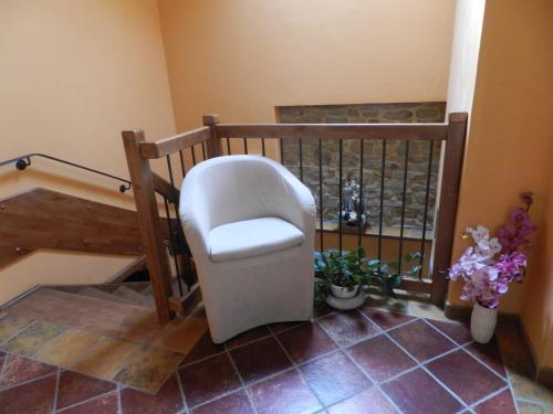 a white chair in a room with a staircase at B&B l'Angolo di Rosina con ristorante in Novello